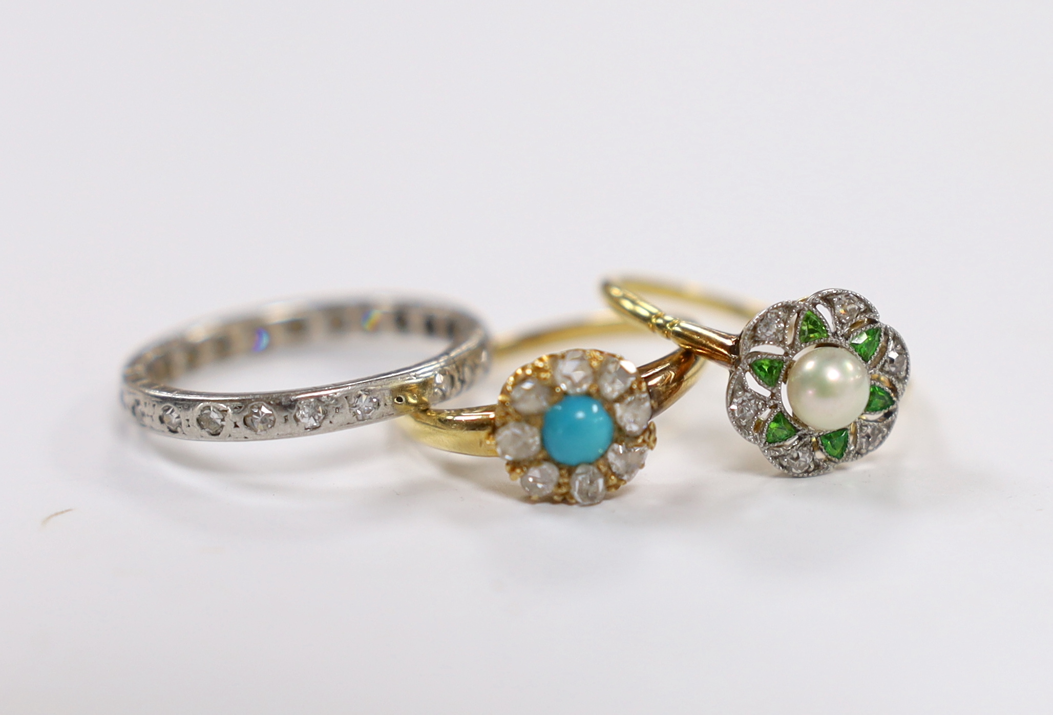 A 1920's yellow metal and millegrain set cultured pearl, diamond and demantoid garnet cluster flower head ring, size M, together with an 18ct, turquoise and rose cut diamond cluster set ring and a white metal and diamond